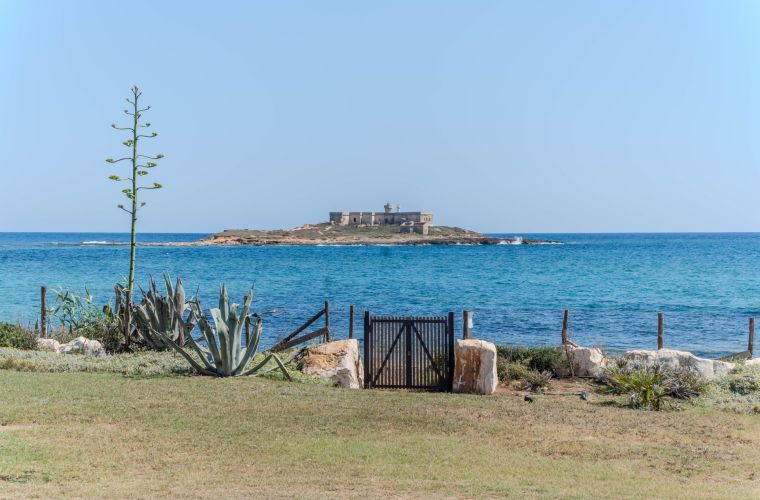 The gate to the beach and the Island delle Correnti